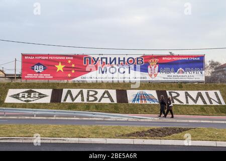 BELGRAD, SERBIEN - 25. DEZEMBER 2014: Menschen, die an einer Plakatwand vorbeigehen, um chinesische Investitionen in Serbien zu fördern. Die Beziehungen zu China und Serbien wachsen Stockfoto