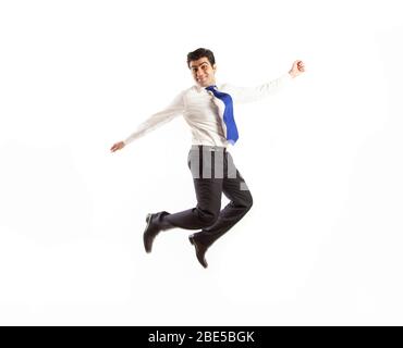 Junger Bürokorporative Mann springen hoch seine Arme mit Freude tragen blaue Krawatte auf einem weißen Hintergrund isoliert Stockfoto