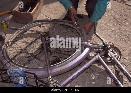 Indischer Fahrradmechaniker in einer Werkstatt im Reparaturprozess Stockfoto