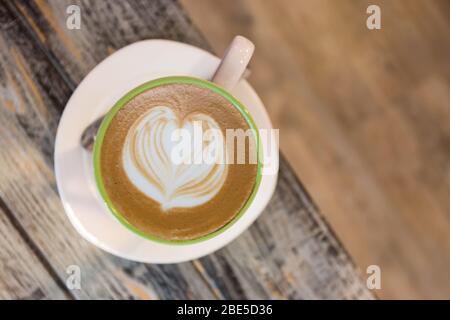 Draufsicht von Cappuchino Kaffee auf Holztisch Hintergrund. Nahaufnahme der Kaffeetasse Stockfoto