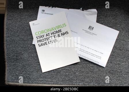 Ein Brief der britischen Regierung, der Ratschläge zur Coronavirus-Pandemie auf einer Fußmatte im Flur gibt. Stockfoto