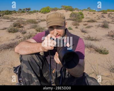 Nahaufnahme eines Fotos eines Ohotographen in der Savanne, der ein wildes Leben eines Tieres fotografiert. Reise- und Journalistenkonzept. Stockfoto
