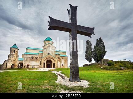 Big Iron Cross vor bagrati Kirche bei bedecktem Himmel in Kutaissi, Georgien Stockfoto