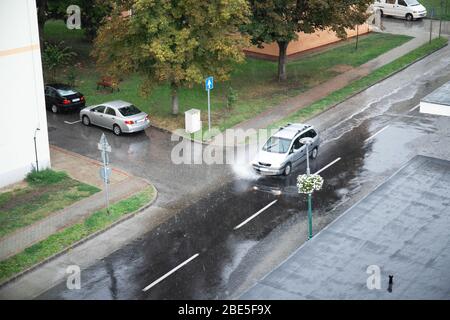 Autoverkehr regen große Pfütze Spritzwasser von den Rädern Stockfoto