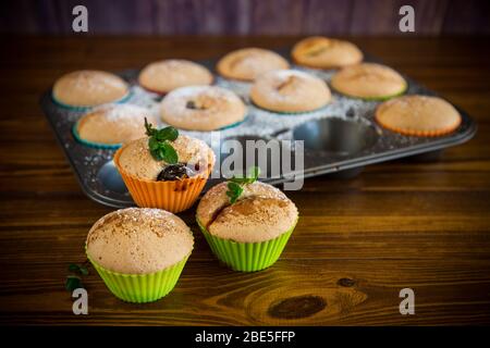 Süß gebackene Muffins mit Fruchtfüllung in Puderzucker Stockfoto