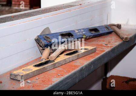 Arbeitswerkzeuge für Mauerwerk. Bauhöhe Hammer Spitzhacke Kelle. Industrieller Hintergrund Stockfoto