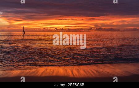 Erstaunlich hell bunten Sonnenuntergang bewölkt Abend schöne helle Reflexion im Sand in der Nähe von Padang, Sumatera, Indonesien Stockfoto