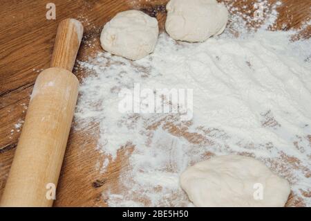 Nudelholz, Teig und Mehl auf dem Tisch. Der Prozess der Herstellung von hausgemachten Kuchen. Hausgemachtes Backen. Kochen von zu Hause Teig. Stockfoto
