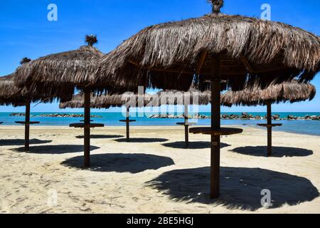 Sonnenschutzschirme am Strand in Italien. Stockfoto