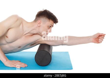 Der gutaussehende Mann zeigt Übungen mit einer Schaumstoffrolle für eine Myofaszialmassage von Triggerpunkten. Massage des Musculus triceps. Isoliert auf weiß. Stockfoto