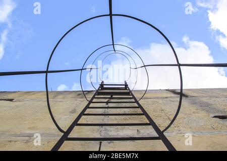 Evakuierungstreppe, die zu einem Dach eines Gebäudes führt. Feuerausgang aus dem Gebäude. Stockfoto