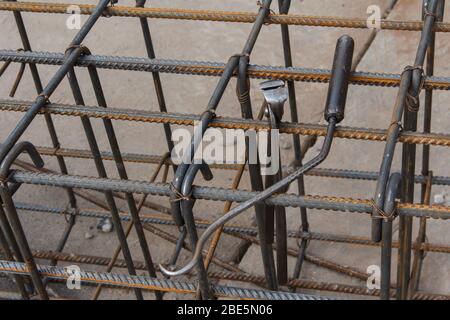 Arbeiter Werkzeug für Stahl Riegel für Gebäude auf der Baustelle. Zangenwerkzeug, Haken und Eisen Drähte zum Stricken von Metallstangen. Stockfoto