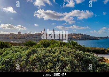 Blick auf Valletta Skyline am schönen Sonnenuntergang von Sliema mit Kirchen Unserer Lieben Frau auf dem Berg Karmel und St. Paul's Anglican Pro-Cathedral, Va Stockfoto