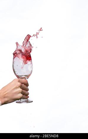 Wein spritzt aus Weinglas Stockfoto