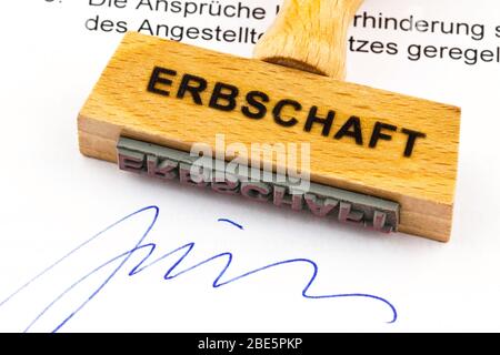 Ein Stempel aus Holz liegt auf einem Dokument. Deutsche Aufschrift: Erbschaft Stockfoto