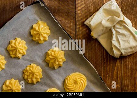 Backblech von Choux Gebäck auf dunklem Holz Hintergrund bereit, im heimischen Holzofen zu backen Stockfoto