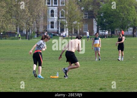 London, Großbritannien, 12. April 2020: Am Ostersonntag beobachten Menschen die sozialen Distanzierungsregeln, während sie am Clapham Common Bewegung und frische Luft in der Sonne nehmen. Anna Watson/ Alamy Live News Stockfoto