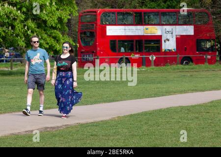 London, Großbritannien, 12. April 2020: Am Ostersonntag beobachten Menschen die sozialen Distanzierungsregeln, während sie am Clapham Common Bewegung und frische Luft in der Sonne nehmen. Anna Watson/ Alamy Live News Stockfoto