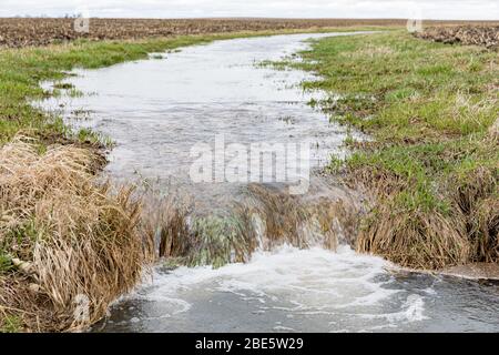 Farm Field Waterway fließendes Wasser nach starken Regen und Stürme verursacht Überschwemmungen. Konzept der Bodenerosion und Wasserabfluss Kontrolle und Management Stockfoto