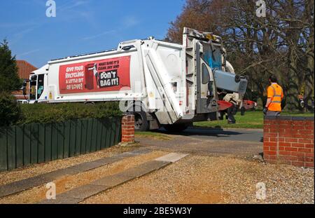 Ein Binman entleert einen Recyclingbehälter in einen Sammelwagen in einem Wohngebiet in Hellesdon, Norfolk, England, Großbritannien, Europa. Stockfoto