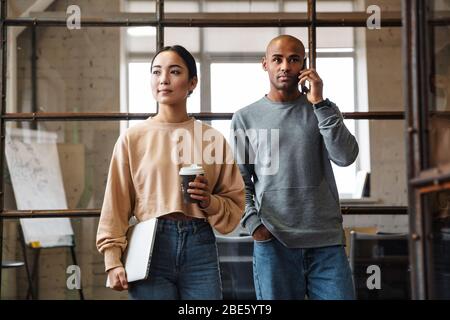 Bild von multiethnischen jungen weiblichen und männlichen Kollegen, die im Büro zusammenarbeiten Stockfoto