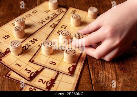 Familie vintage interessante Lotto Bingo-Spiel, Hand hält ein Fass mit einer Zahl Stockfoto