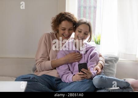 Glücklich teen Tochter und junge Mutter mit Smartphone zu Hause Stockfoto