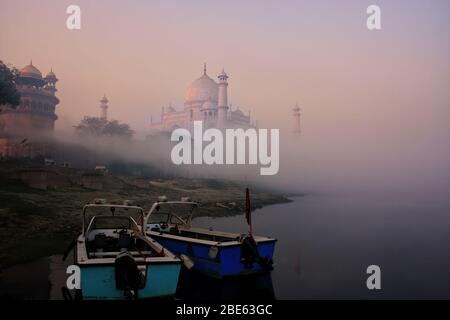 Boote ankerten am Fluss Yamuna nahe Taj Mahal am frühen Morgen, Agra, Uttar Pradesh, Indien. Taj Mahal wurde zum UNESCO-Weltkulturerbe i ernannt Stockfoto