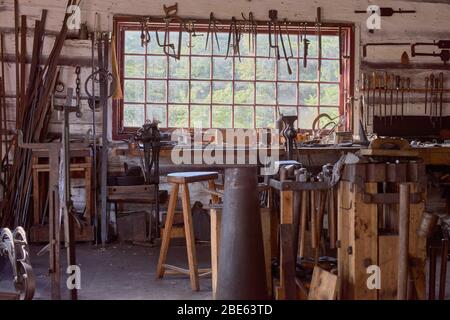Großer Tisch am Fenster Alte Vintage Handwerkswerkstatt Schmied Mit einem Zangenstock und anderen Werkzeugen Stockfoto