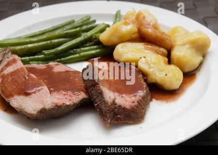 Lammkeule mit hausgemachten Gnocchi und grünen Bohnen Stockfoto