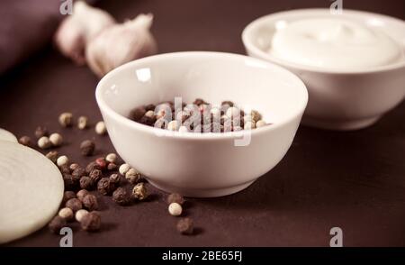 Paprika rot, schwarz, weiß in einer weißen kleinen Schüssel gemischt Stockfoto