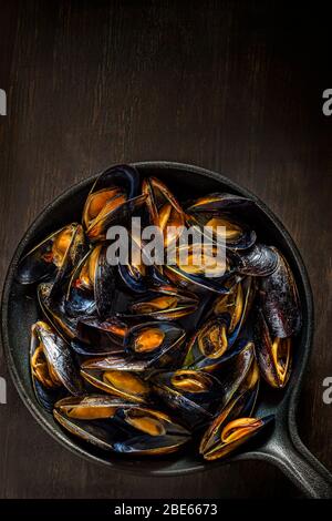 Gedämpfte Muscheln in Gusseisen Topf. Stockfoto