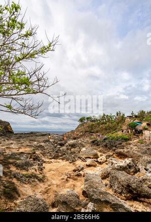 Vertikale Ansicht von Touristen, die um Angel's Billabong auf Nusa Penida, Indonesien laufen. Stockfoto