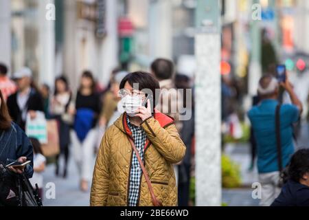 Reisende treffen Vorsichtsmaßnahmen durch das Tragen von Gesichtsmasken, tokyo Street, verhindern Corona Virus, Japanese Street, tokyo, bovid 19 Schutz, Gesundheitsvorkehrungen Stockfoto