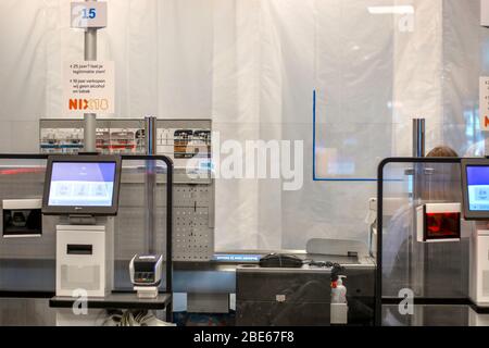 Schutzfolien aus Kunststoff und Plexiglas an den Kassen im Supermarkt installiert, um die Verbreitung des Coronavirus zu verhindern. Kassenschalter mit Schutzschildern Stockfoto