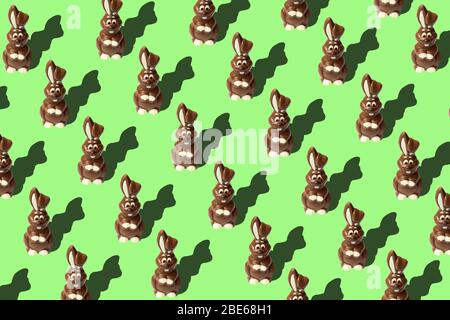 Ostermuster mit Schokoladenkaninchen auf hellgrünem Hintergrund. Ostern Konzept Bild mit Milch Schokolade Kaninchen Stockfoto