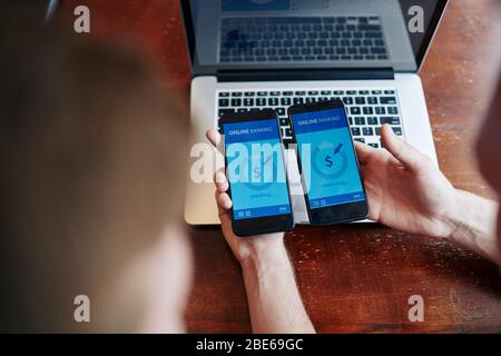 Junger Mann, der Geld über eine mobile Banking-Anwendung an einen Freund oder Kollegen übergibt Stockfoto