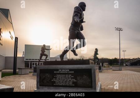 Syracuse, New York, USA. 12. April 2020. Jim Brown Statue prominent mit Statuen von Ernie Davis und Floyd Little im Hintergrund am Clifford J. Stockfoto