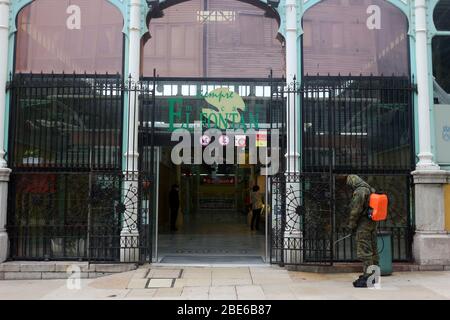 Oviedo, Spanien. April 2020. Oviedo, SPANIEN: Ein Mitglied der spanischen Armee desinfiziert am 12. April 2020 die Tür des Mercado del Fontan am 30. Tag des Alarmstaates in Spanien in Oviedo, Spanien. (Foto von Alberto Brevers/Pacific Press) Quelle: Pacific Press Agency/Alamy Live News Stockfoto