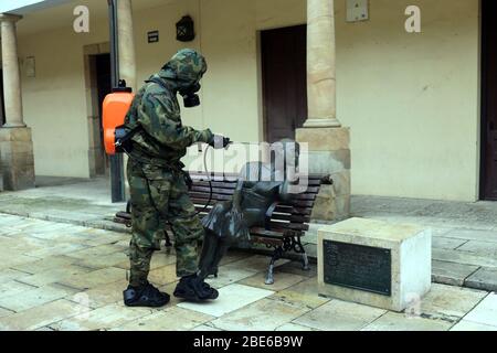 Oviedo, Spanien. April 2020. Oviedo, SPANIEN: Ein Soldat der spanischen Armee desinfiziert am 12. April 2020 eine Skulptur auf der Plaza del Fontán am 30. Tag des Alarmzustands in Spanien in Oviedo, Spanien. (Foto von Alberto Brevers/Pacific Press) Quelle: Pacific Press Agency/Alamy Live News Stockfoto