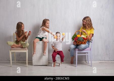 Jungen und drei Mädchen mit einem Korb von Gemüse und Obst Stockfoto