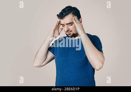 Männer im T-Shirt, die die Hände an den Kopf halten. Gesundheitliche Probleme. Leiden an Problemen zu Hause oder am Arbeitsplatz. Stockfoto