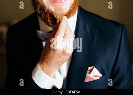 Kurzer Blick auf einen schönen Mann, der seinen roten Bart berührt Stockfoto