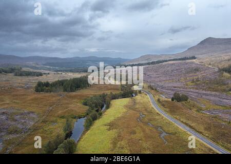 Drone schießen bei bewölktem herbstlichen Morgen über leeren asphaltierte Straße A87 in der Nähe von Loch Loyne in der nordwestlichen Highlands von Schottland entlang der Nordküste 500 Stockfoto