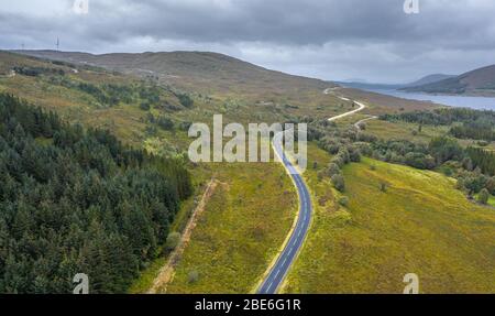 Drohnenschießen am wolkigen Herbstmorgen über der leeren Asphaltstraße A87 in der Nähe von Loch Loyne im Nordwesten der schottischen Highlands Stockfoto