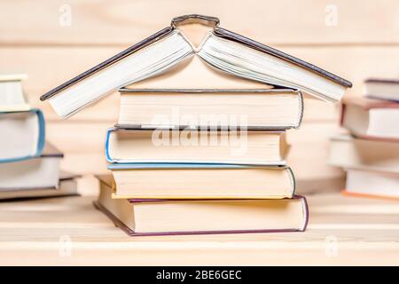 Druckausgaben. Verlag. Konzept für den Aufenthalt zu Hause. Haus mit Büchern auf Holzhintergrund gestapelt gemacht. Stapel von Büchern. Bildungskonzept. Stapel von Stockfoto