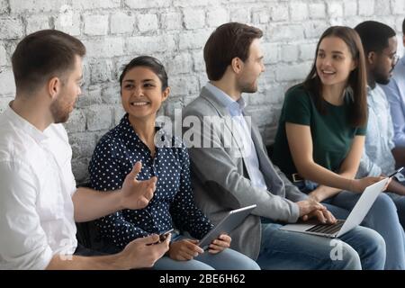 Lächelnde multiethnische Bewerber haben Spaß vor dem Interview im Büro Stockfoto