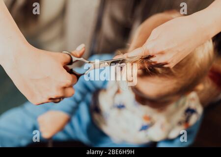 Erster Haarschnitt des kleinen Jungen zu Hause durch Eltern. Schwarzweiß-Porträt. Stockfoto