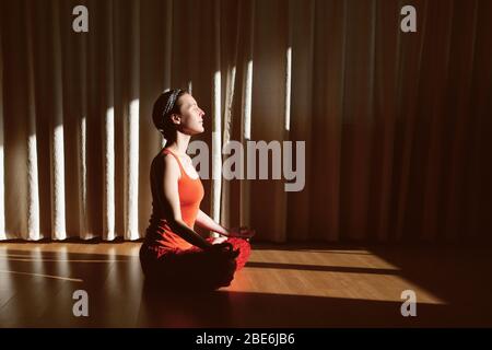 Schöne junge Frau meditiert zu Hause. Stockfoto