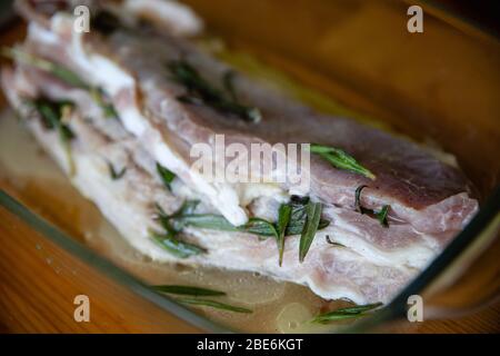 Rohes, fettes Schweinefleisch, gewürzt mit Salz, Papper, Knoblauch und Rosmarin, fertig zum Kochen Stockfoto